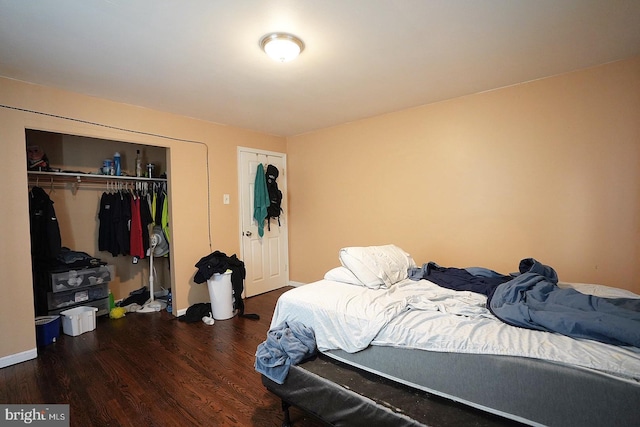 bedroom with dark wood-style flooring, a closet, and baseboards