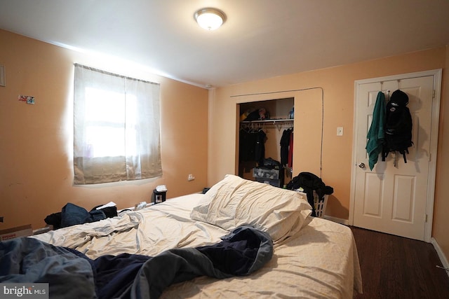 bedroom featuring dark wood-style flooring and a closet