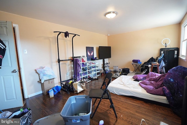 bedroom with baseboards and dark wood finished floors