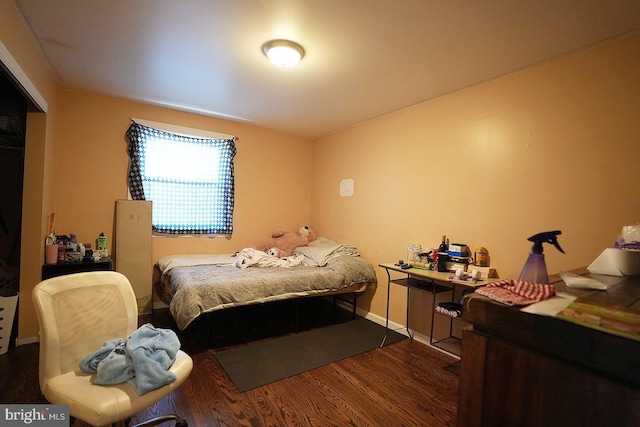 bedroom with dark wood-style flooring and baseboards