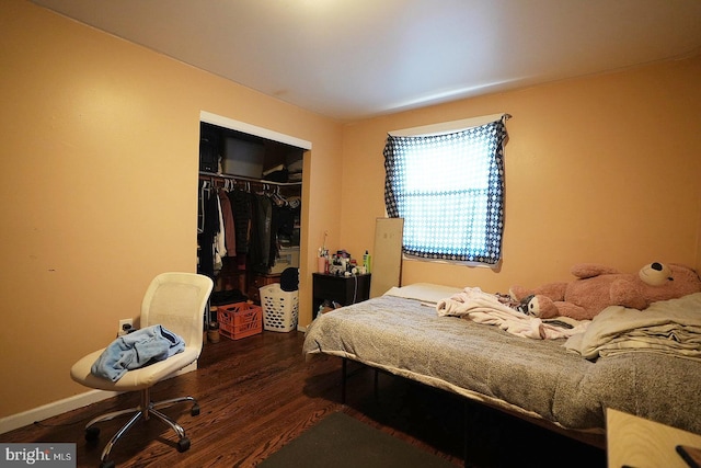 bedroom with a closet, baseboards, and wood finished floors