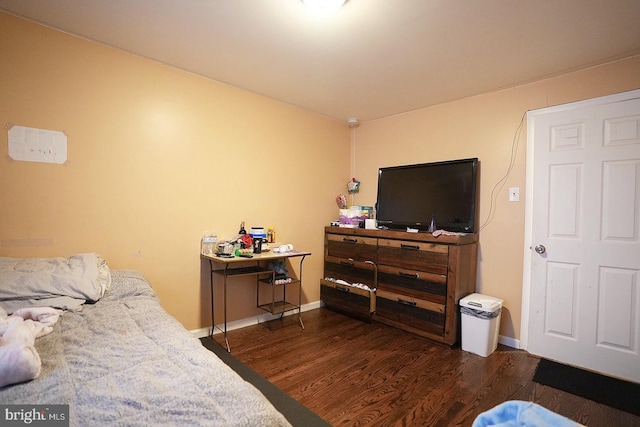 bedroom with dark wood-style floors and baseboards