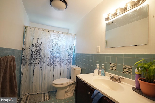 bathroom featuring wainscoting, toilet, curtained shower, vanity, and tile walls