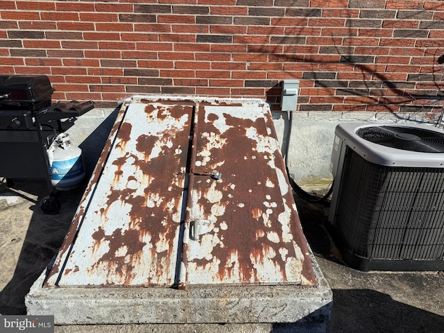 details featuring brick siding and central AC unit