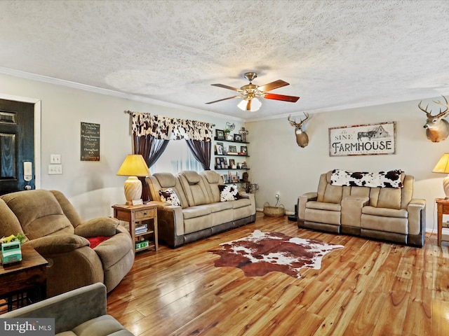 living room with a textured ceiling, ornamental molding, and hardwood / wood-style floors
