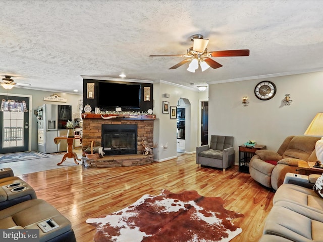 living area with ceiling fan, a textured ceiling, arched walkways, and wood finished floors