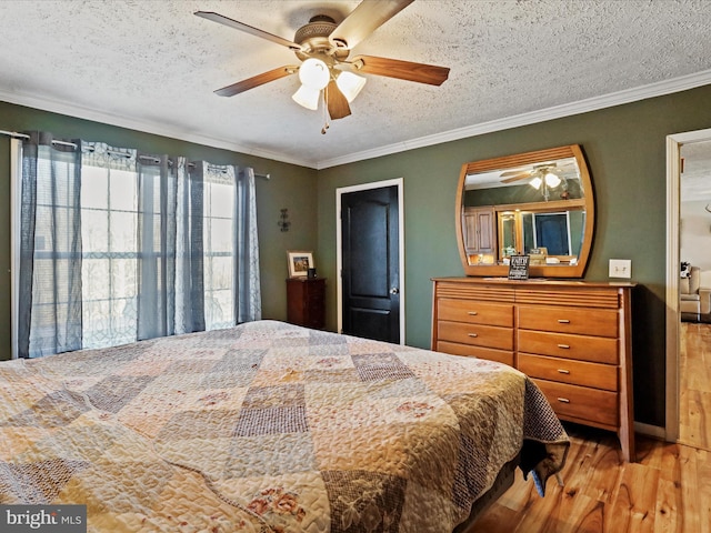 bedroom featuring a textured ceiling, ceiling fan, ornamental molding, and wood finished floors