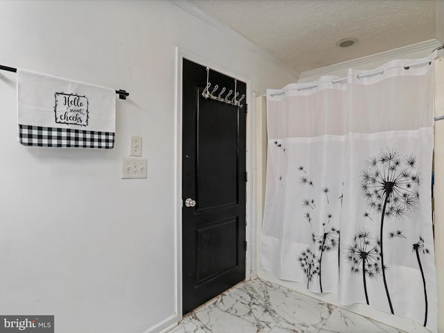 bathroom with marble finish floor, crown molding, a textured ceiling, and a shower with shower curtain