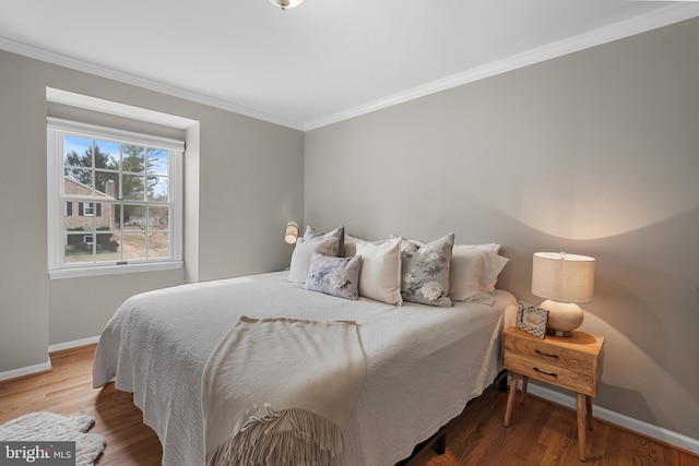 bedroom featuring ornamental molding, baseboards, and wood finished floors