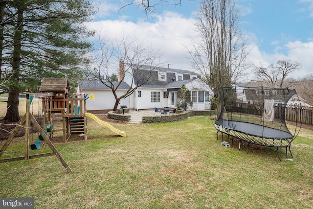 view of yard with a trampoline, a patio area, a playground, and fence