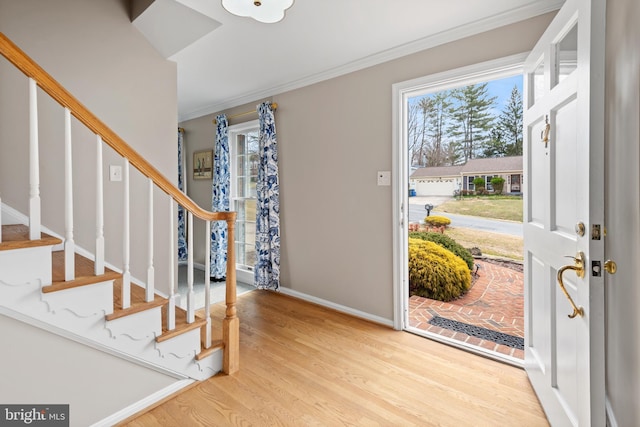 foyer entrance featuring stairway, wood finished floors, and crown molding