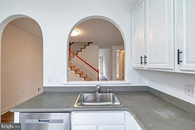 kitchen featuring a sink, dark countertops, white cabinetry, and stainless steel dishwasher