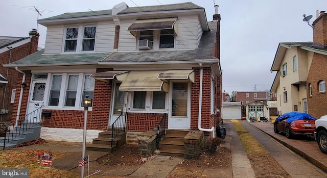 view of front of property with entry steps, brick siding, and a chimney