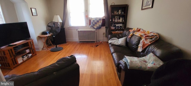 living room with radiator heating unit and wood finished floors