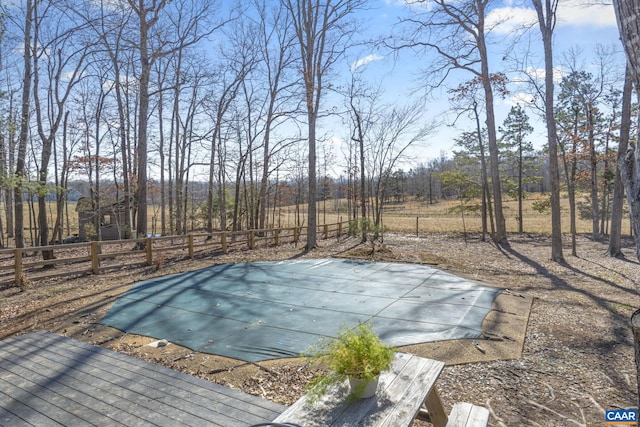 view of swimming pool featuring fence