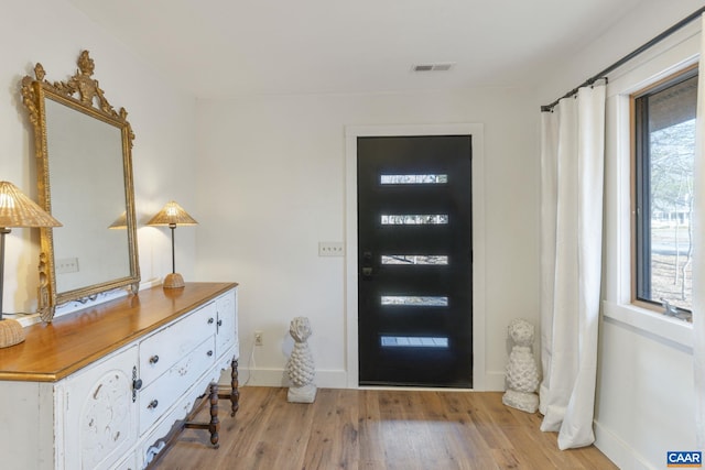 entrance foyer with baseboards, visible vents, and light wood finished floors