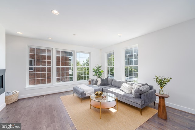 living area featuring visible vents, baseboards, recessed lighting, and wood finished floors