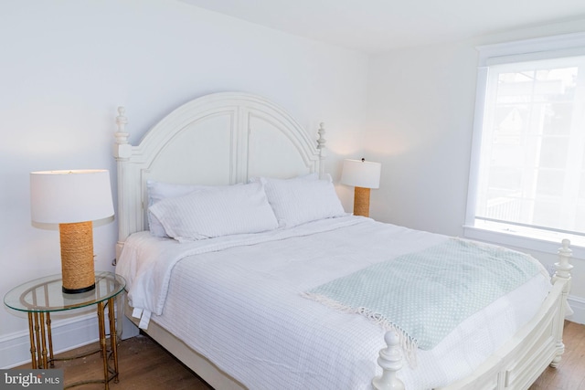 bedroom featuring multiple windows and wood finished floors