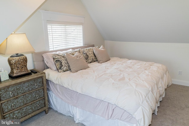 carpeted bedroom featuring vaulted ceiling and baseboards