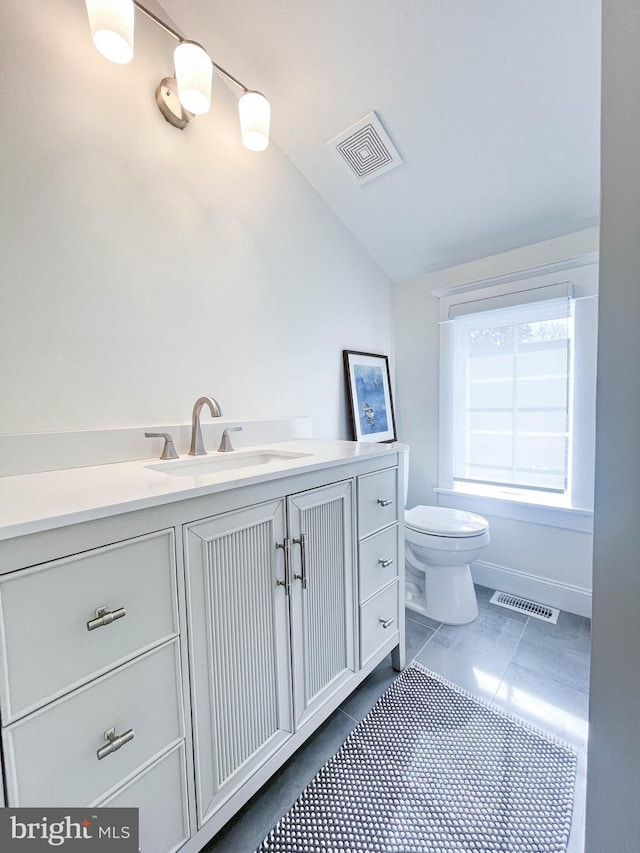 bathroom featuring toilet, vaulted ceiling, visible vents, and vanity