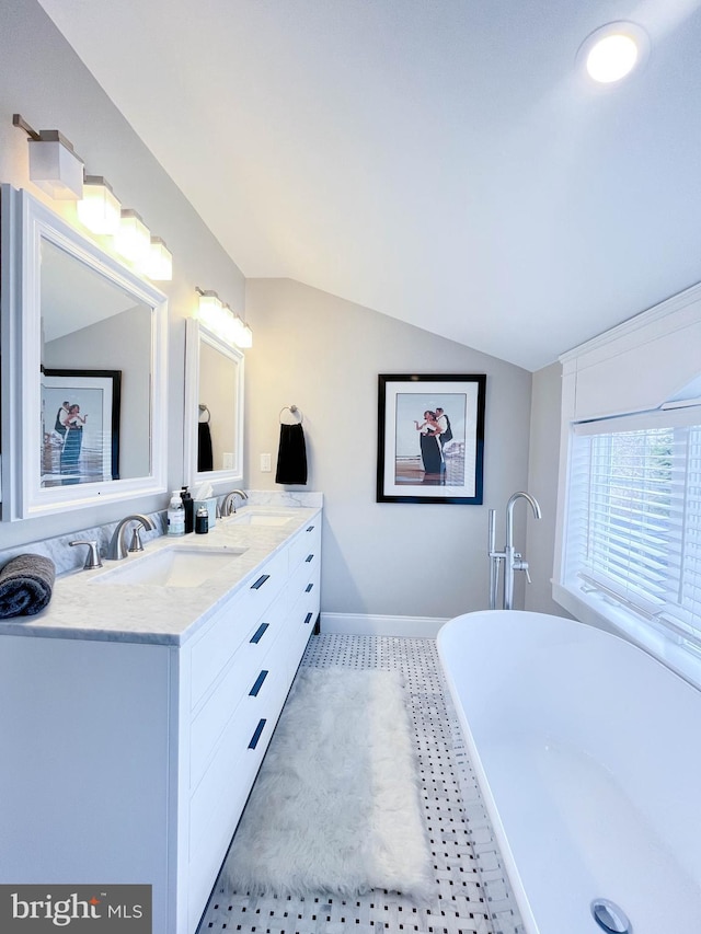 full bathroom featuring tile patterned floors, vaulted ceiling, double vanity, and a sink