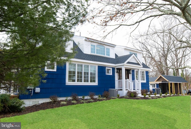 view of front of property with central AC, a front lawn, and a shingled roof