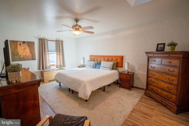 bedroom with wallpapered walls, light wood finished floors, a ceiling fan, and baseboards