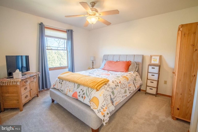 bedroom featuring light carpet, baseboards, and a ceiling fan