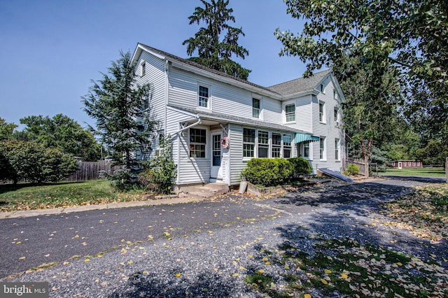 traditional-style home featuring entry steps and fence