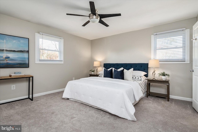 bedroom featuring light carpet, a ceiling fan, and baseboards