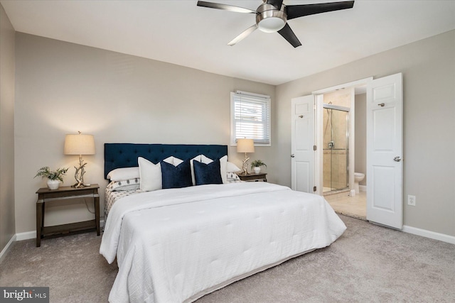 carpeted bedroom featuring baseboards, a ceiling fan, and ensuite bathroom