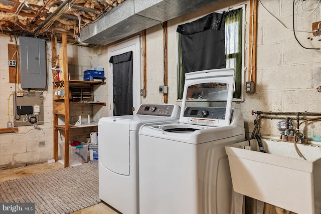 washroom featuring electric panel, laundry area, a sink, and washing machine and dryer