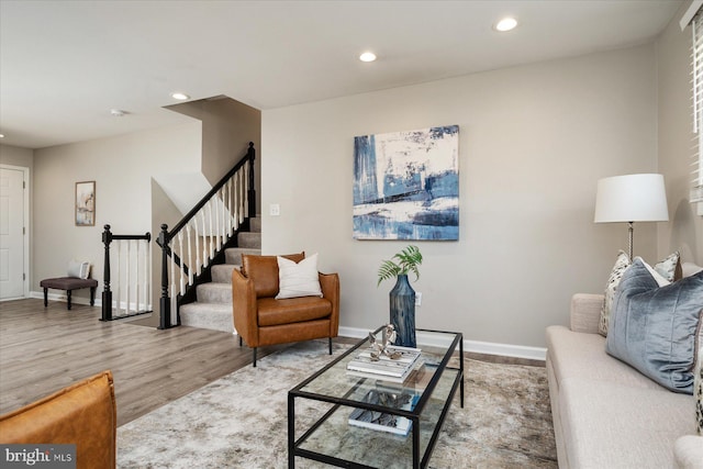 living room with stairway, light wood-type flooring, recessed lighting, and baseboards