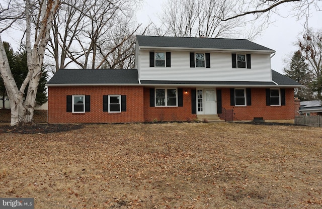 view of front of home with entry steps, brick siding, and roof with shingles