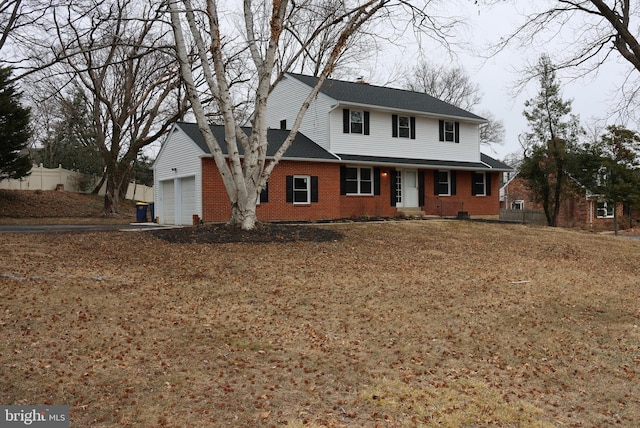 view of front of home featuring brick siding, an attached garage, and fence