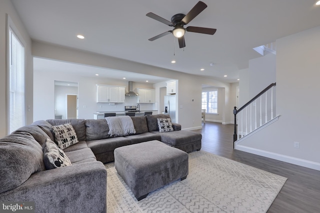 living area featuring baseboards, stairs, wood finished floors, and recessed lighting