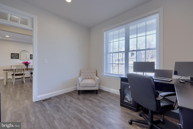 office area with baseboards, visible vents, and light wood-type flooring