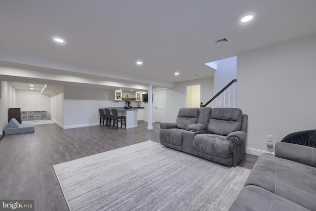 living area featuring baseboards, visible vents, stairway, wood finished floors, and recessed lighting