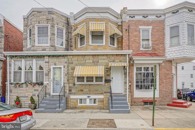 view of property with brick siding, cooling unit, and entry steps