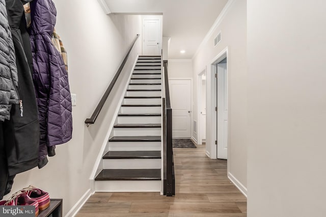 stairway featuring recessed lighting, visible vents, ornamental molding, wood finished floors, and baseboards