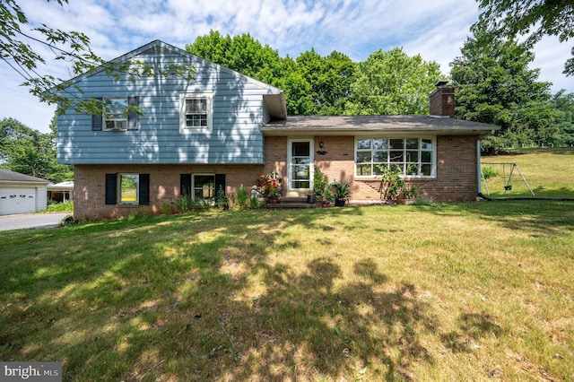 tri-level home with brick siding, a chimney, and a front lawn