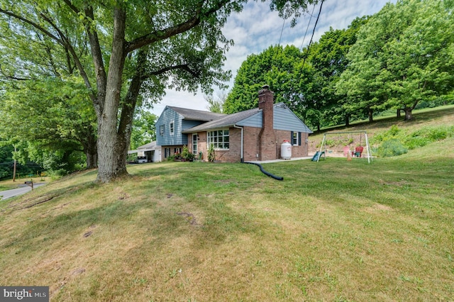 exterior space featuring a yard, a chimney, and brick siding