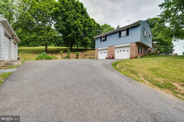 view of home's exterior with a garage, a yard, aphalt driveway, and brick siding