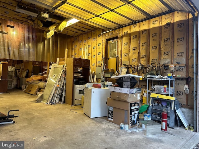 interior space with unfinished concrete flooring, a workshop area, and washer / dryer