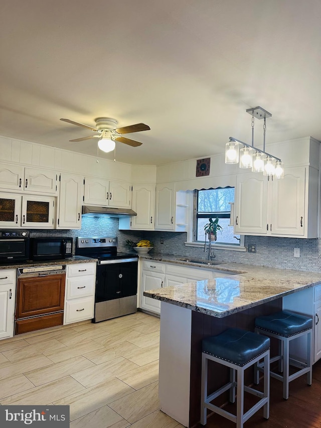 kitchen with white cabinetry, stainless steel range with electric cooktop, and decorative light fixtures