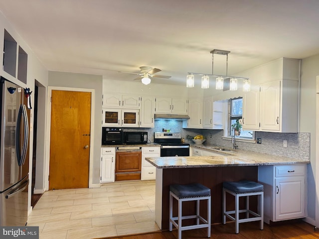 kitchen featuring stainless steel appliances, a peninsula, white cabinets, and under cabinet range hood