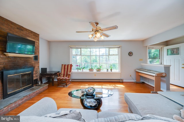 living area with baseboards, baseboard heating, a fireplace, and light wood-type flooring