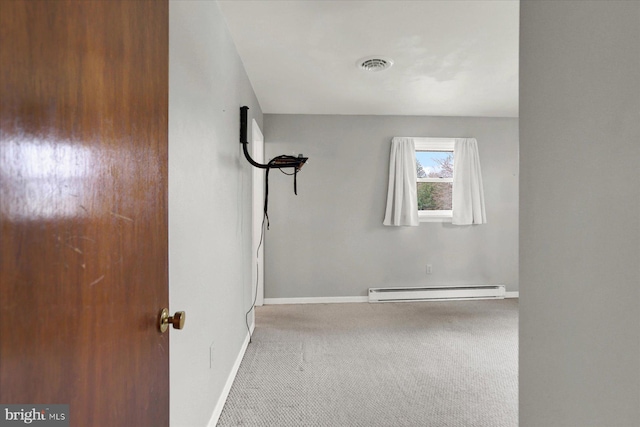 carpeted spare room with baseboards, visible vents, and a baseboard radiator