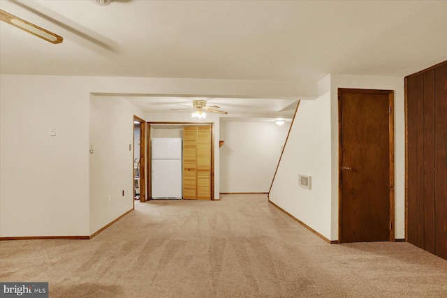 unfurnished room with baseboards, carpet, and a ceiling fan