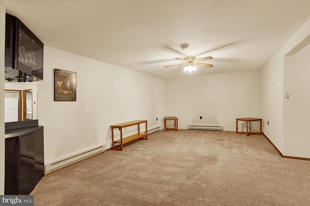 carpeted empty room featuring ceiling fan, baseboards, and a baseboard radiator